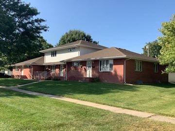 Kearney apartment for rent - a red house with a lawn and a sidewalk