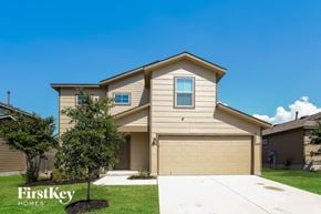 San Antonio house for rent - a tan house with a garage door and a green lawn