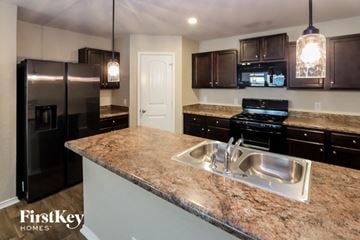 San Antonio house for rent - a kitchen with granite counter tops and black appliances