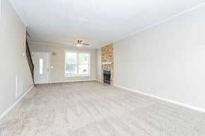 Madison house for rent - an empty living room with carpet and a fireplace