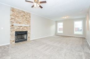 Madison house for rent - an empty living room with a fireplace and a ceiling fan