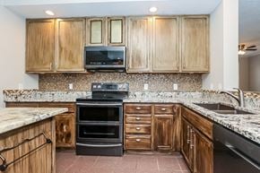 Madison house for rent - a kitchen with granite counter tops and wooden cabinets