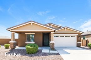 Buckeye house for rent - A modern house with a brown exterior and a large front yard.