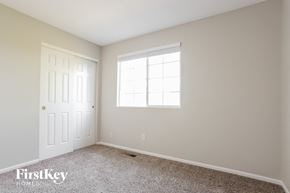 Aurora house for rent - a bedroom with a white door and a window and carpet