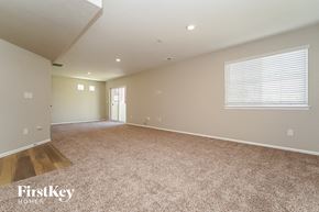 Aurora house for rent - an empty living room with carpet and a window