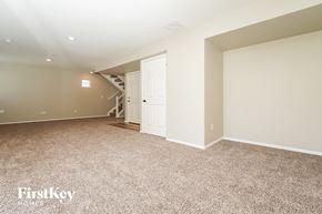 Aurora house for rent - an empty living room with a door to a staircase