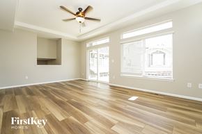 Aurora house for rent - an empty living room with wood floors and a ceiling fan
