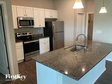 Cape Coral house for rent - a kitchen with a granite counter top and a sink