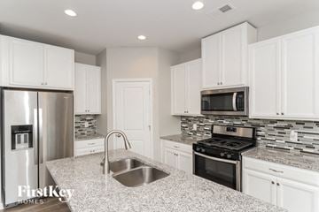 Austell house for rent - a kitchen with white cabinets and stainless steel appliances