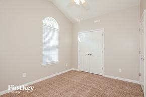 Gastonia house for rent - a bedroom with a carpeted floor and a white door