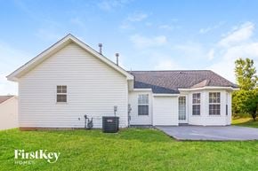 Gastonia house for rent - the front of a white house with a driveway and grass
