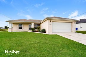 Lehigh Acres house for rent - A house with a garage and a driveway in front of it.