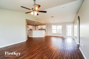 Lehigh Acres house for rent - A spacious room with a ceiling fan and wooden flooring.