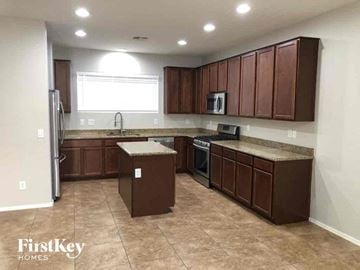 Phoenix house for rent - A kitchen with brown cabinets and a refrigerator.