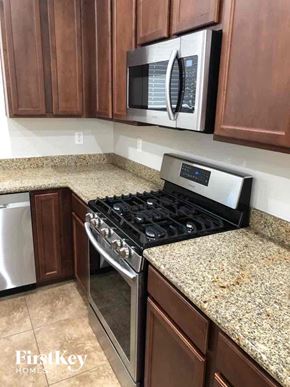 Phoenix house for rent - A kitchen with a stove top oven and a microwave above it.
