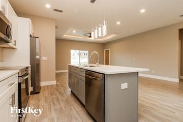 Poinciana house for rent - a large kitchen with stainless steel appliances and a white counter top