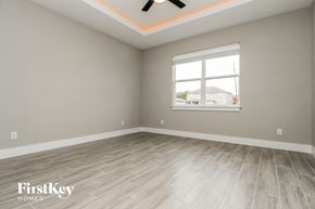 Poinciana house for rent - the living room with a large window and wood flooring