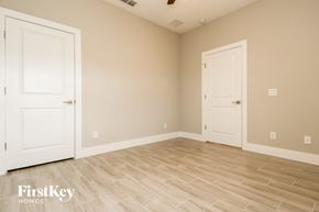 Poinciana house for rent - a bedroom with two doors and a wood floor