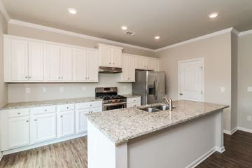 Canton house for rent - a kitchen with white cabinets and a granite counter top