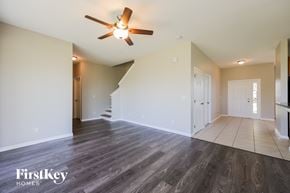 Lehigh Acres house for rent - A spacious room with a wood floor and a ceiling fan.