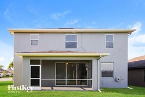 Lehigh Acres house for rent - A modern house with a grey exterior and a large glass door.