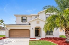 Jacksonville house for rent - A white house with a brown garage door and a palm tree in front.