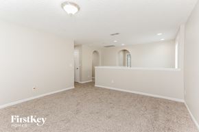 Jacksonville house for rent - A spacious empty room with a carpeted floor and a window.