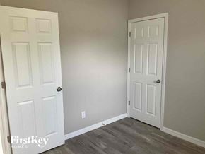 Lehigh Acres house for rent - a bedroom with two white doors and a wood floor