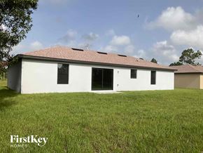 Lehigh Acres house for rent - front view of a white house with a yard and grass