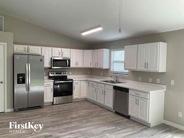 Lehigh Acres house for rent - a white kitchen with stainless steel appliances and white cabinets