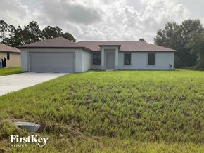 Lehigh Acres house for rent - a house with a yard and a garage