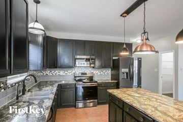 Westfield house for rent - a large kitchen with black cabinets and granite counter tops