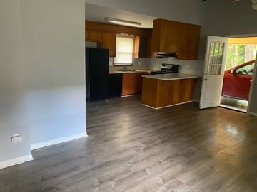 Monroe apartment for rent - A kitchen with wooden cabinets and a black fridge.