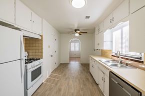 Albuquerque house for rent - an empty kitchen with white cabinets and stainless steel appliances