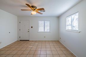 Albuquerque house for rent - an empty living room with a ceiling fan and a tile floor