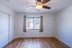 Albuquerque house for rent - an empty living room with a ceiling fan and a window