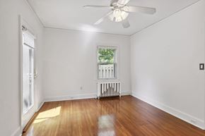 Minneapolis apartment for rent - A room with a ceiling fan and a window with a view of trees.