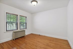 Minneapolis apartment for rent - A room with wooden floors and a window with blinds.