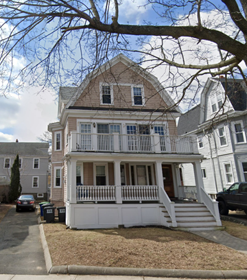 Somerville apartment for rent - A two-story house with a white porch and a brown roof.