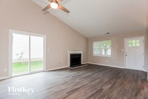 Charlotte house for rent - A spacious room with a fireplace and sliding glass doors.
