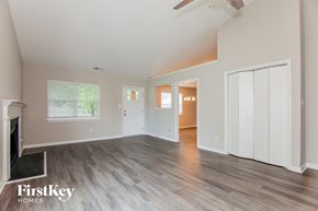 Charlotte house for rent - A spacious room with a fireplace and wooden flooring.