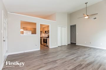 Charlotte house for rent - A spacious room with a kitchen visible through a window in the background.