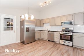 Charlotte house for rent - A kitchen with wooden floors and stainless steel appliances.