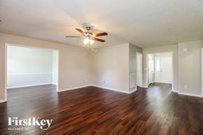 Greensboro house for rent - the living room and dining room with hardwood flooring and a ceiling fan