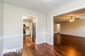 Greensboro house for rent - an open living room and kitchen with wood flooring and a ceiling fan