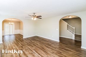 Austell house for rent - A spacious room with wooden floors and a ceiling fan.