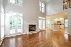 Greensboro house for rent - A large, empty room with a fireplace and wooden floors.