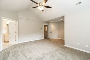 Greensboro house for rent - A spacious room with a ceiling fan and carpeted floor.