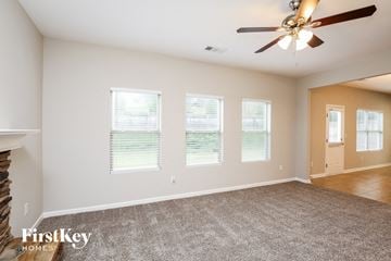 Dawsonville house for rent - a living room with a carpet and a ceiling fan