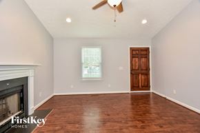 Mount Juliet house for rent - an empty living room with a fireplace and wood flooring